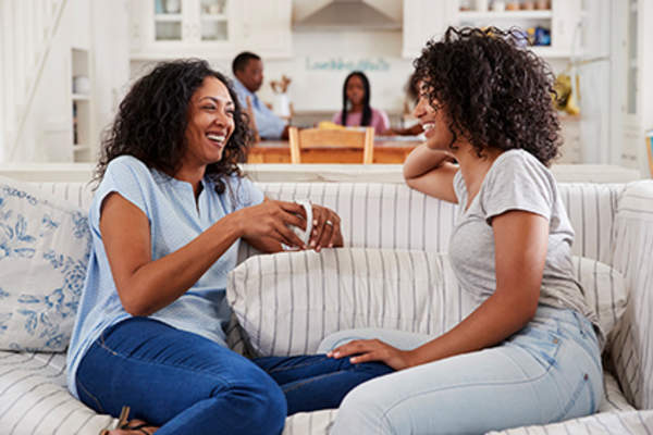 Mother and daughter talking on the couch.