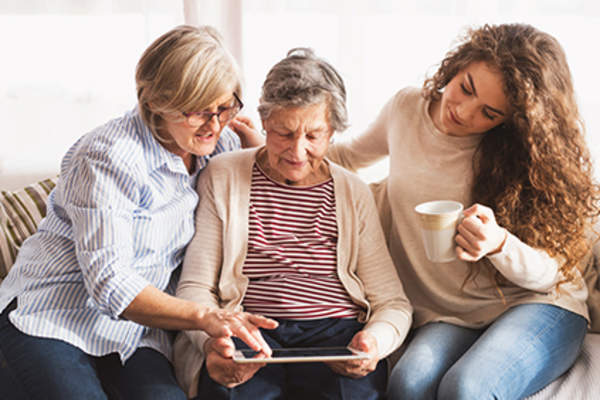 Three generations of women using a tablet.