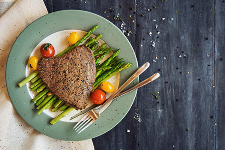 Tenderloin steak with grilled asparagus and cherry tomatoes.