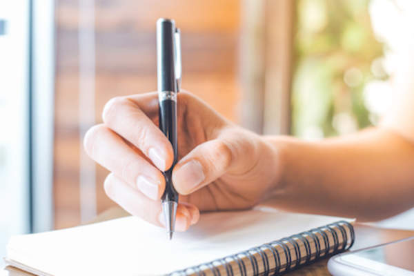 Woman doing calculations on notepad.