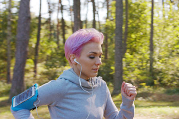 Young woman jogging on a wooded trail.