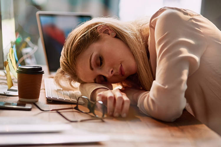 Exhausted woman sleeping at her desk.