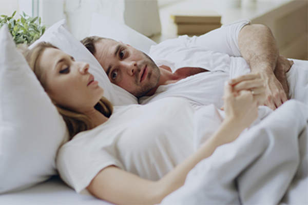 Young couple talking in bed.