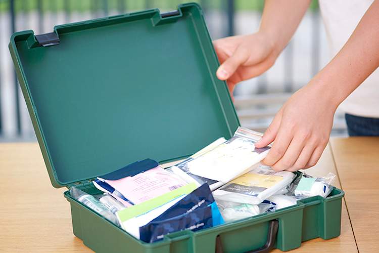 Woman packing an emergency medical supplies kit.