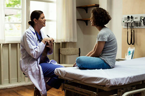 Doctor explaining something to a young patient.