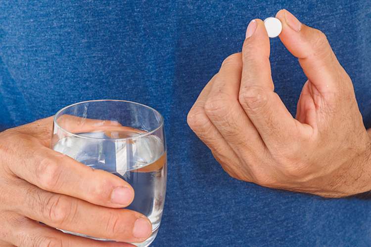 Man taking aspirin with a glass of water.