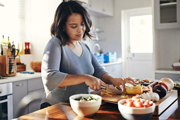 Young woman making dinner.