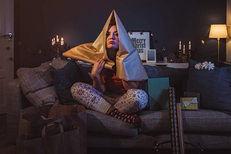 Upset woman at home with Christmas gifts.