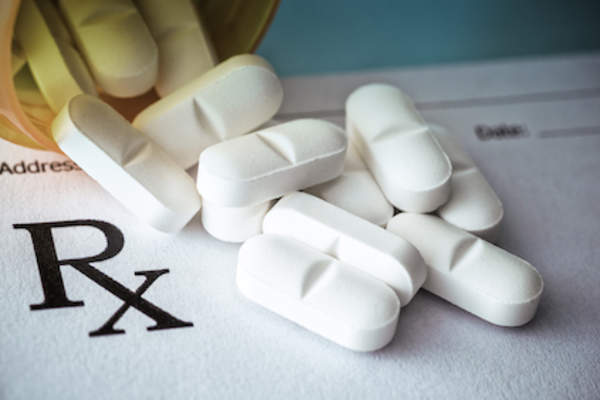 Prescription pills spilling out on to prescription pad.