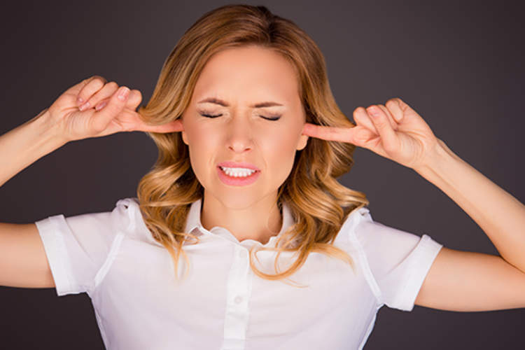 Woman plugging her ears with her fingers.