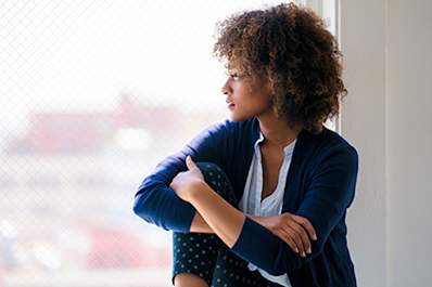 Woman looking out the window while deep in thought.