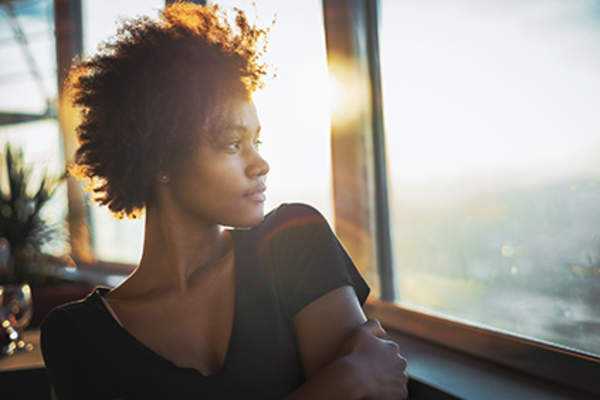 Pensive woman looking outside.