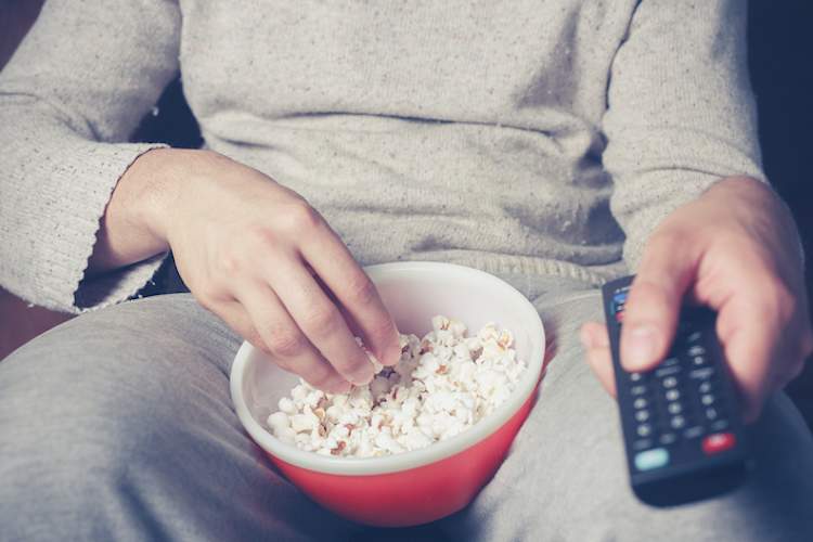 eating popcorn on couch in sweats.
