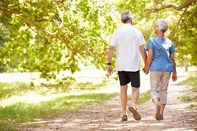 Elderly couple walking together in the park.