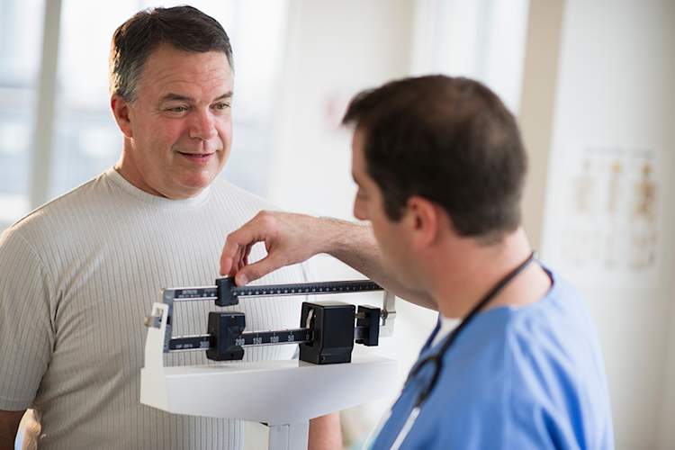 Doctor weighing a patient