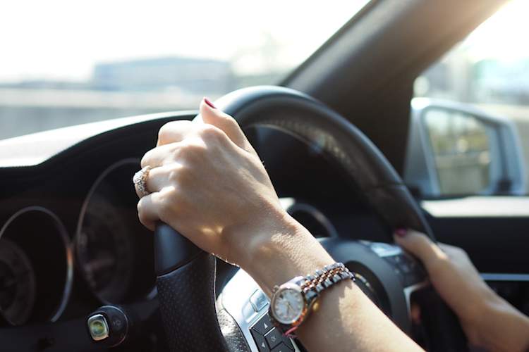 Woman's hands on steering wheel.