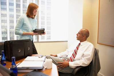 Coworkers talking at a desk.