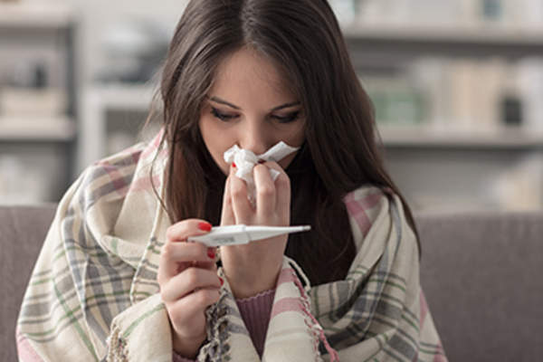 Sick woman taking her temperature.