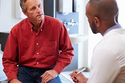 A man talks with his doctor about back pain.