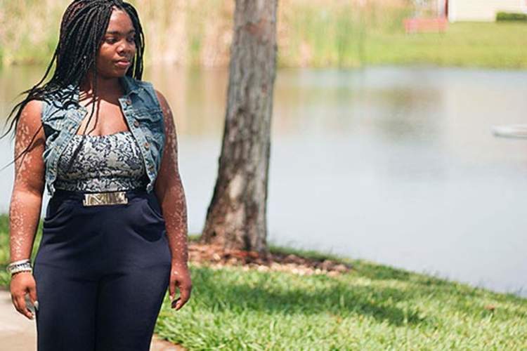 A woman walking by a lake.