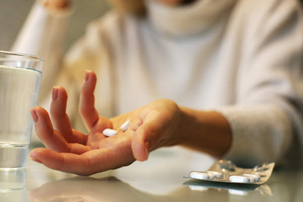 woman taking pain medication image