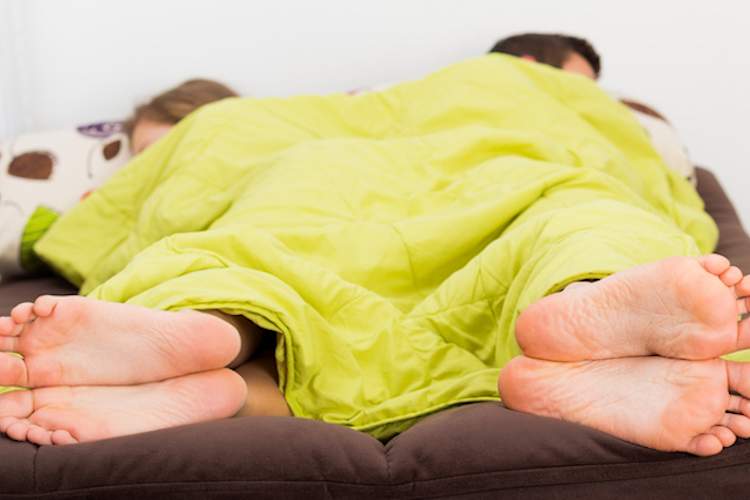 Couple facing away from each other in bed.