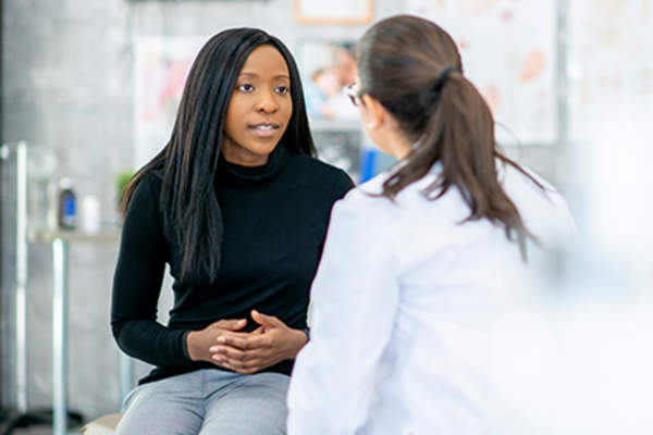 Woman discussing ulcerative colitis with her doctor.