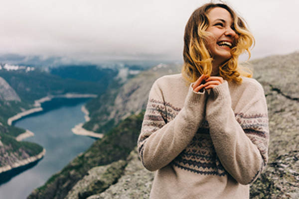 Hopeful woman smiling in front of a beautiful vista.
