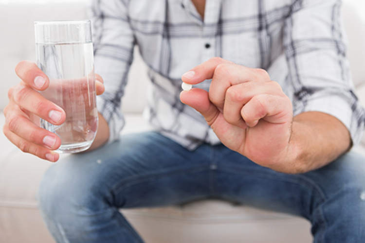 Man with a pill in his hand