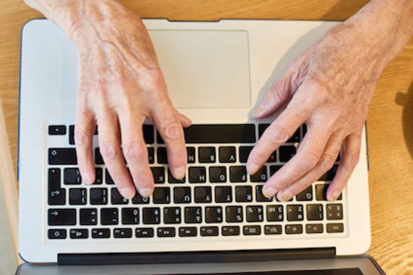 Woman journaling her pain on computer.