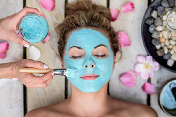 Woman getting a face mask at a spa.