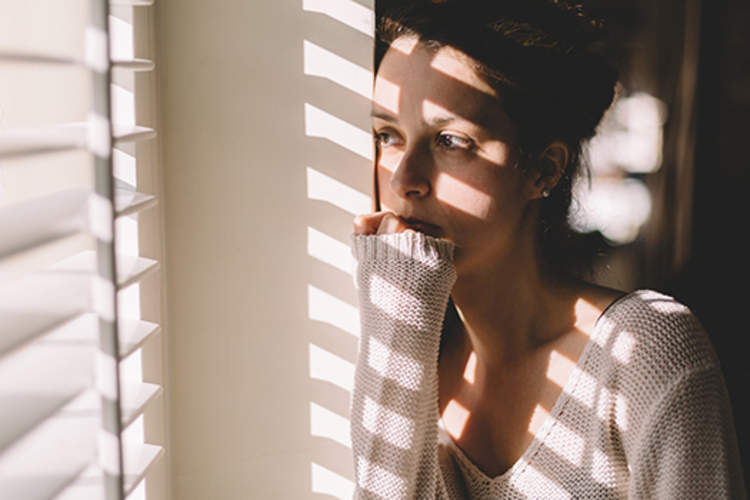 Sad woman looking through the window