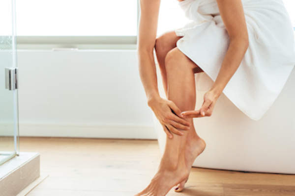 woman applying moisturizer after shower.
