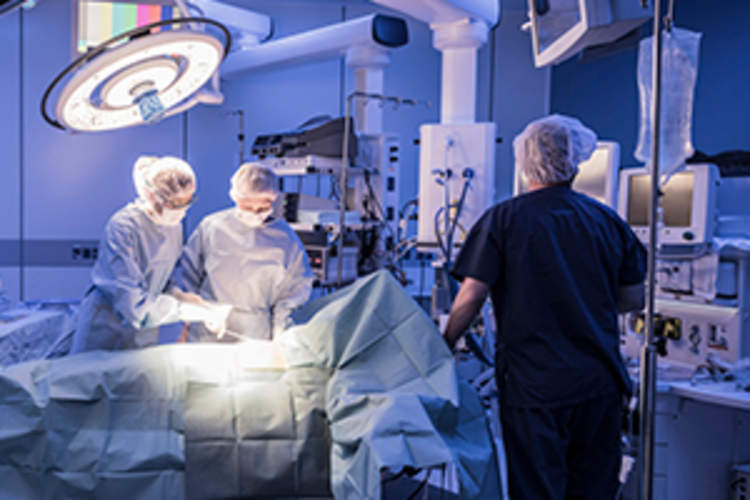 Team of surgeons operating on patient in hospital.