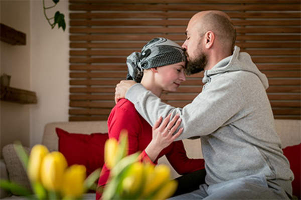 Husband kissing his wife during her cancer treatment.