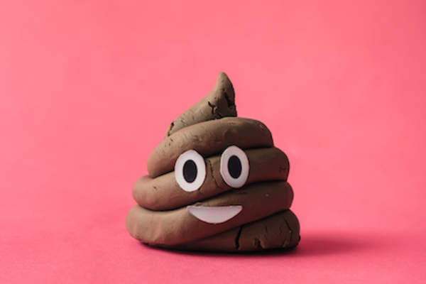 Poop emoticon on pink background.