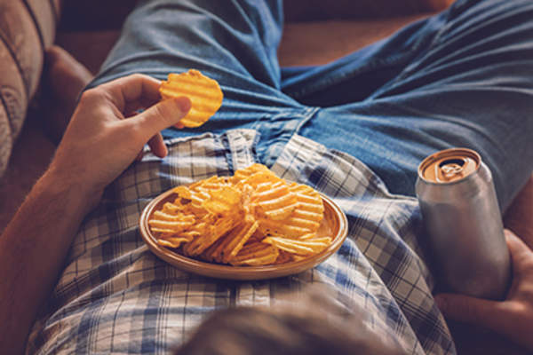 Man eating chips at night.