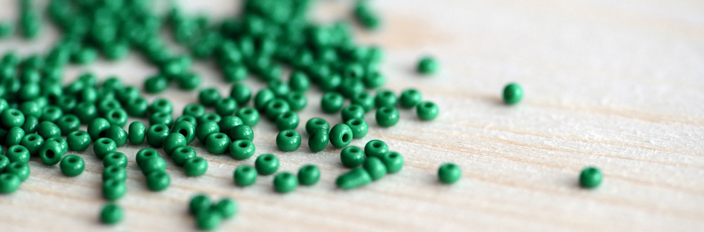 Close-up van groene kralen verspreid over een houten oppervlak
