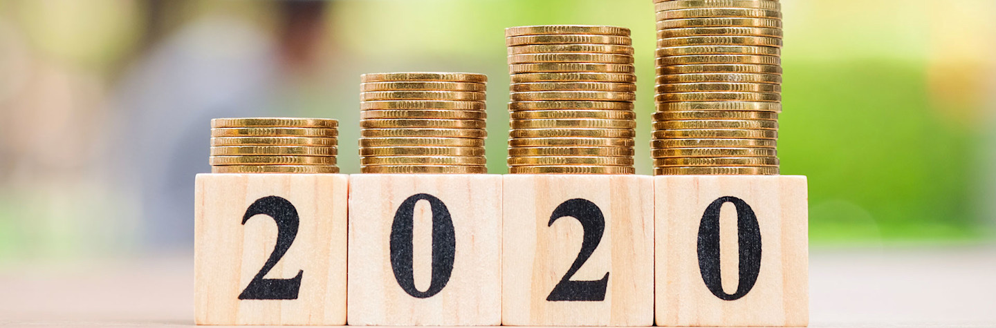 4 oplopende stapeltjes met munten op houten blokken met jaartal 2020