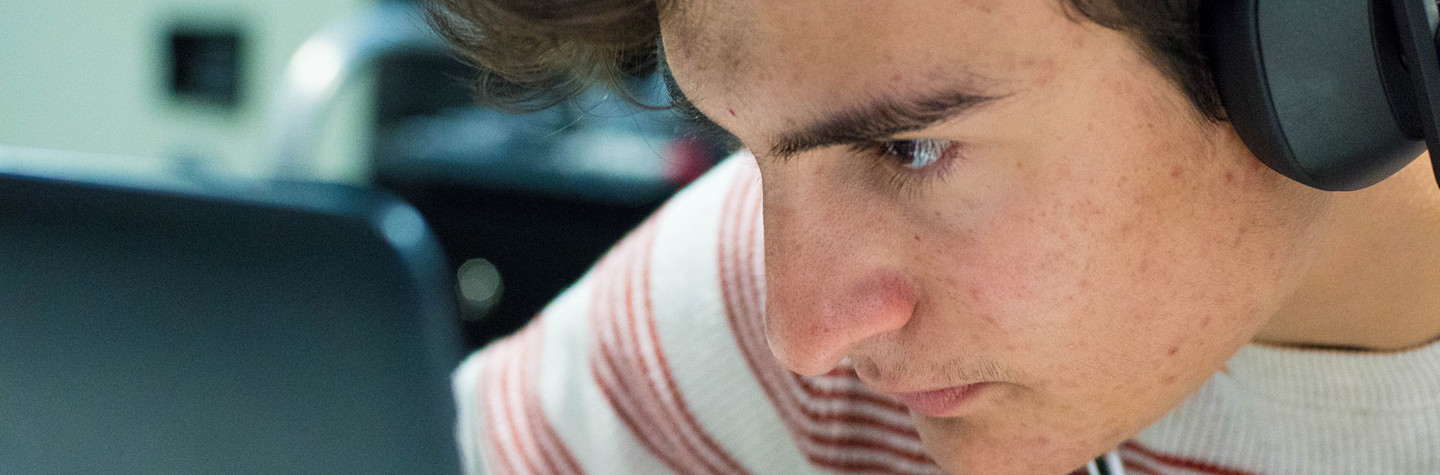 Tiener kijkt ingespannen naar een laptopscherm