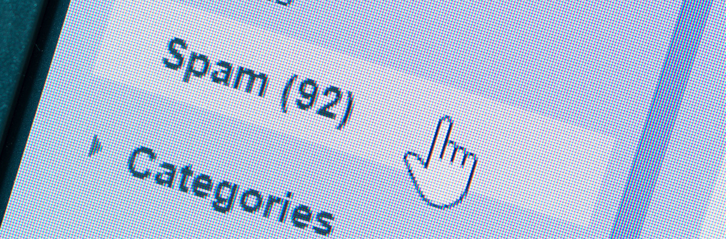 Close-up of a monitor with a mouse pointer hovering over the spam folder in a mailbox.