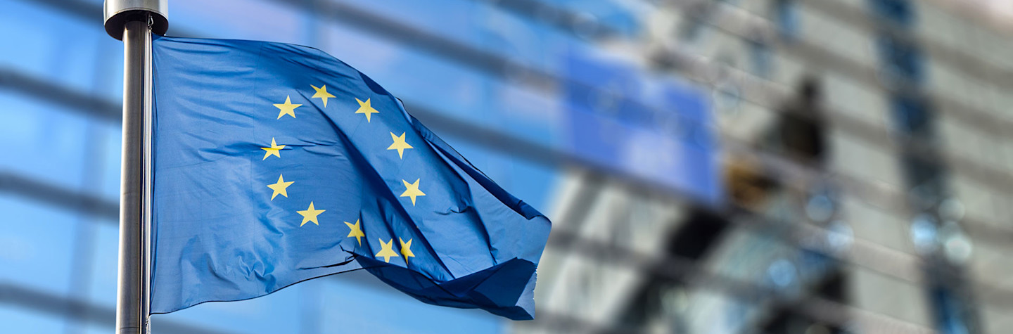 Waving flag of the European Union in front of the European Parliament building in Brussels, Belgium