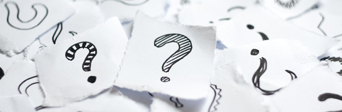 Veel vraagtekens op stukje wit papier