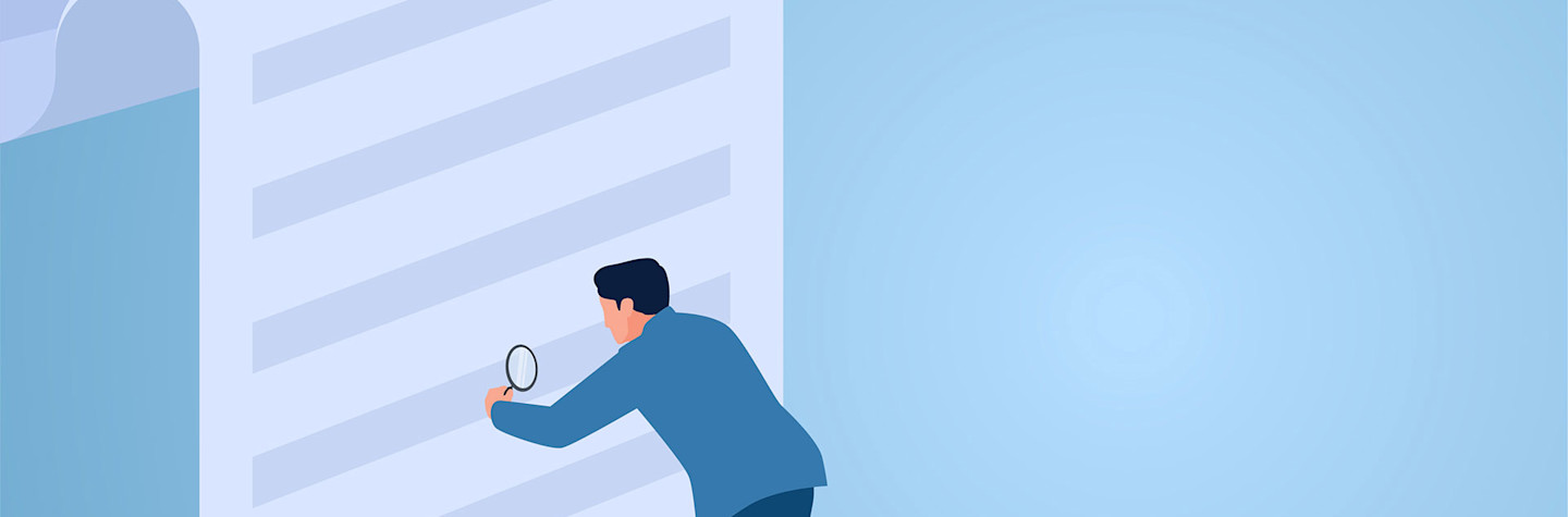 Man examines terms on paper with a magnifying glass