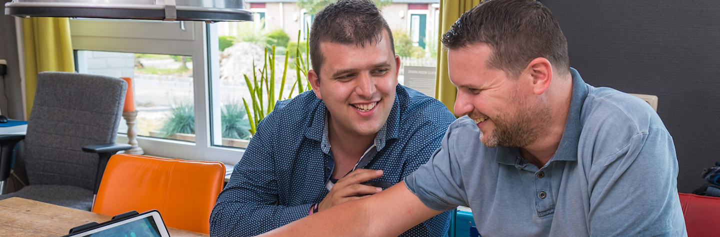 Twee mannen die MediaJungle spelen op een tablet en bordspel.