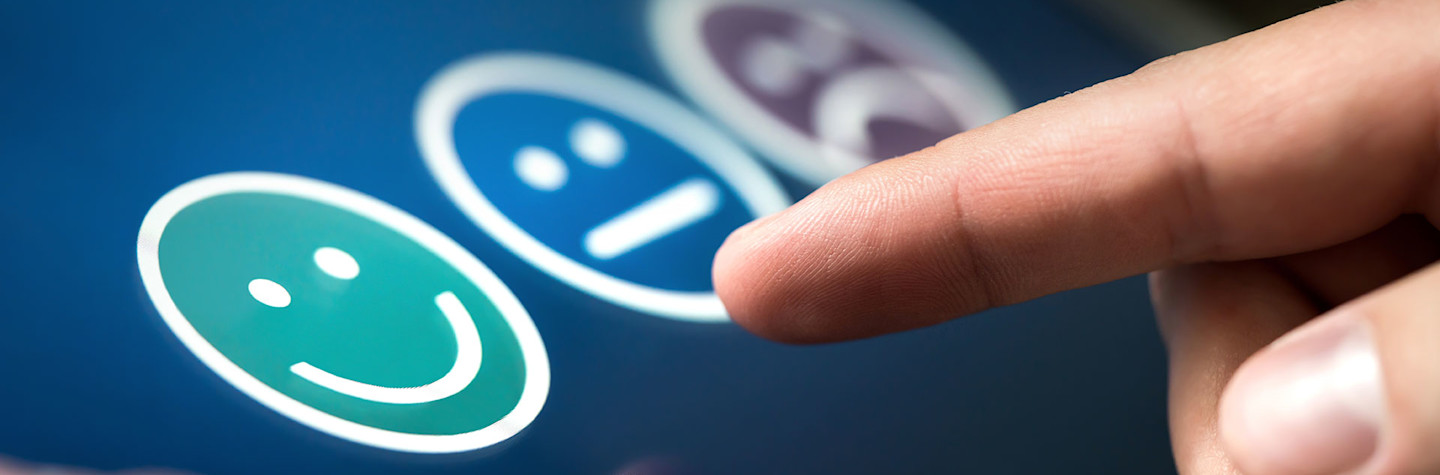 Someone choosing his opinion with smiley faces on touch screen