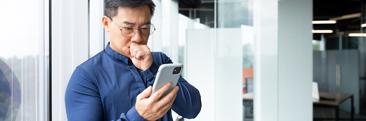 Asian man looks worried on mobile as fraud has been committed against his domain name