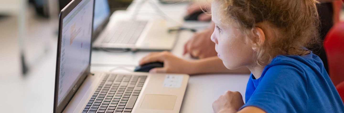 Kinderen werkend op laptops in een klaslokaal