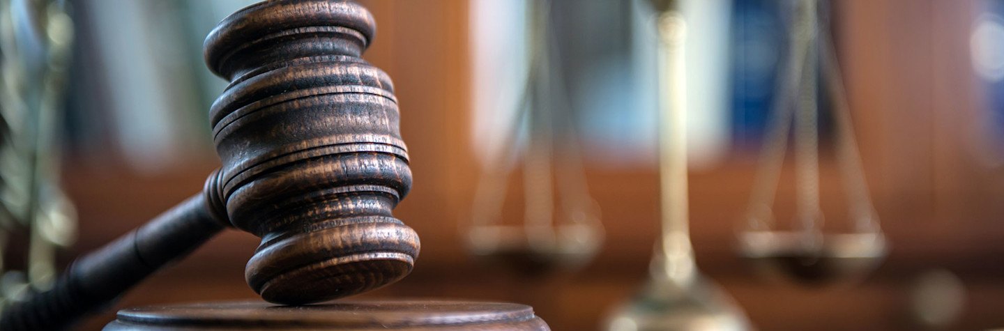 Close-up of a gavel with a scale in the background.