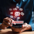 E-mailicoontjes met een rood uitroepteken die opdwarrelen uit een smartphone met daarbij de tekst 'WARNING'.